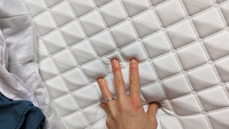 HiGrid Premium Hybrid mattress close up with hand on cover
