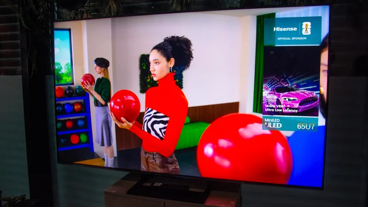 The Hisense U7S TV displaying a lady in a red jumper holding a red bowling ball