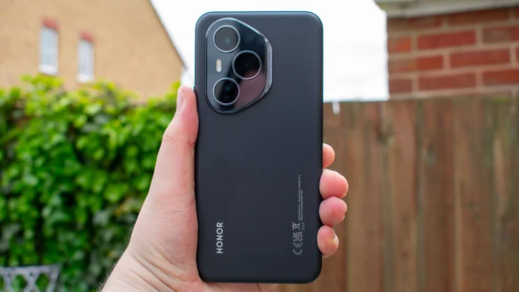 Honor Magic 400 Pro in hand, rear view, in front of a fence