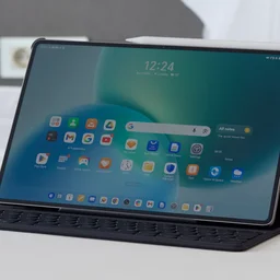 The Honor MagicPad 4 in its keyboard case on on a white bed spread