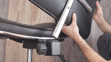 A man dismantles an office chair