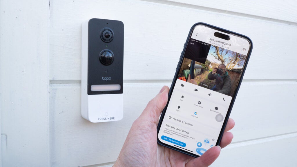 Picture of a phone with a video doorbell in the background