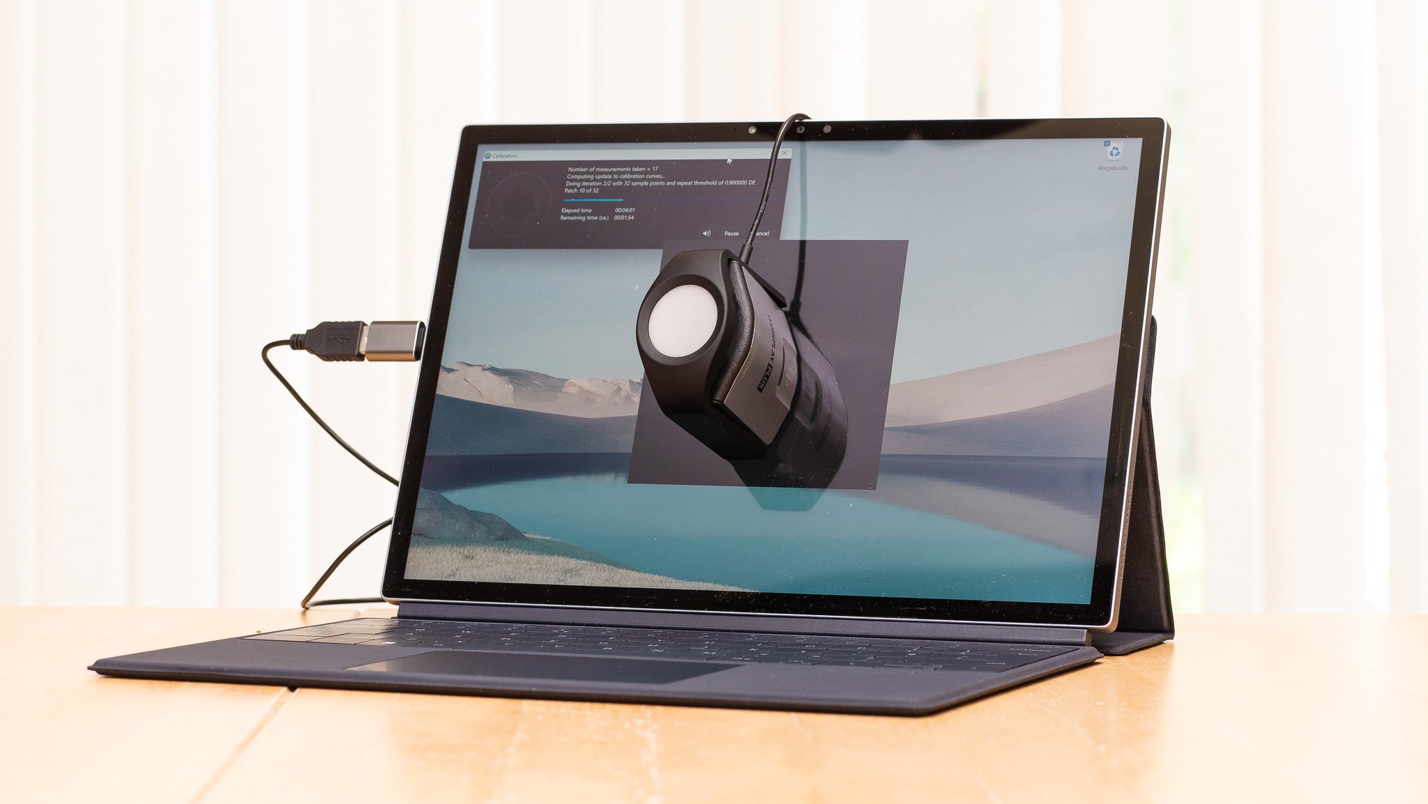 Best laptop. Side view of a laptop on a table undergoing tests using colorimeter