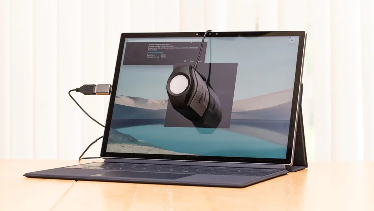 Best laptop. Side view of a laptop on a table undergoing tests using colorimeter