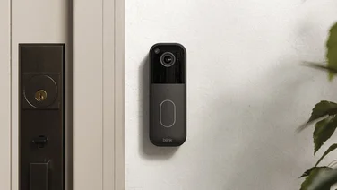The Blink Video Doorbell (2ns generation) pictured mounted on a wall next to a front door