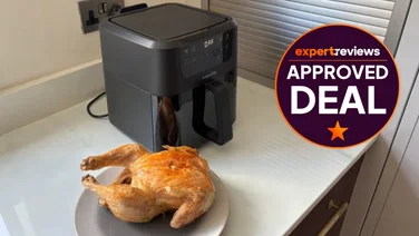 The Instant Pot Vortex air fryer on a kitchen counter, behind a plate of cooked chicken. To the right of the of the air fryer, a badge reads Expert Reviews Approved Deal