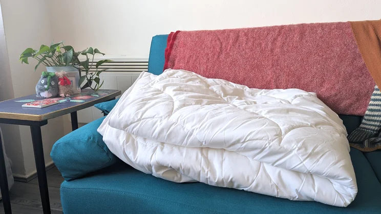The Larke Nature's Blend duvet folded up on a blue sofa