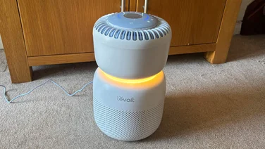 The Levoit Sprout air purifier, glowing orange
