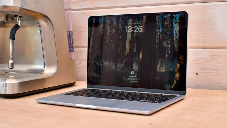 M4 MacBook Air, open, pictured at an angle from the right on a wood workbench