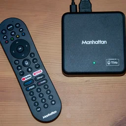 Top-down view of the Manhattan Aero 4K TV Streamer with Freely box and its remote control