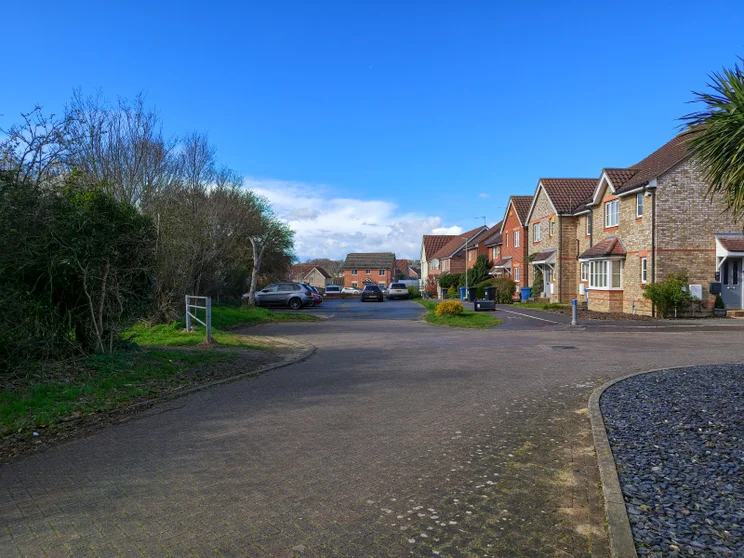 Quiet close of houses with trees on the left