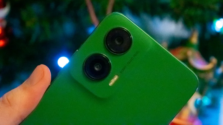 Close up of the Motorola Moto G35 5G's rear cameras, in hand, in front of a Christmas tree