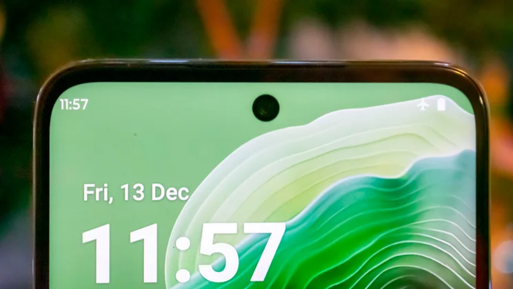 Close up of the Motorola Moto G35 5G's display and selfie camera, in front of a Christmas tree