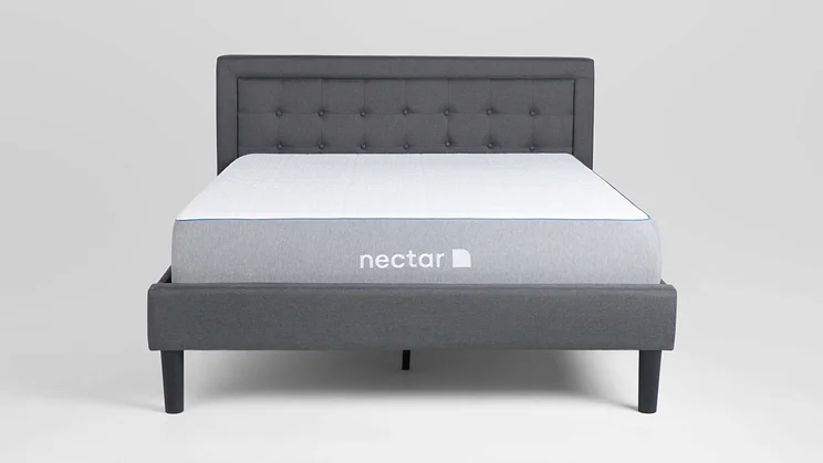 nectar essential hybrid mattress on an upholstered bed frame, on a grey background