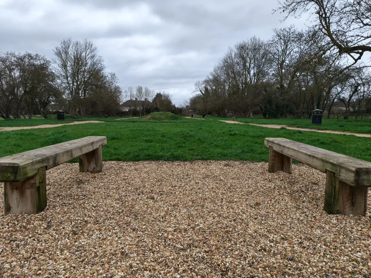 A park with two benches in the foreground