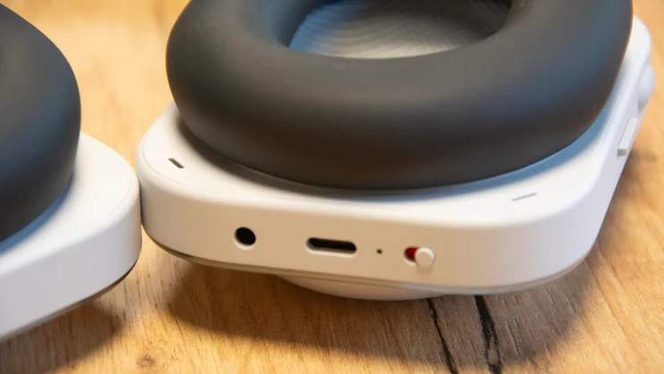 Close-up of the left earcup of the Nothing Headphone (a) over-ear headphones showing the connection ports and power button