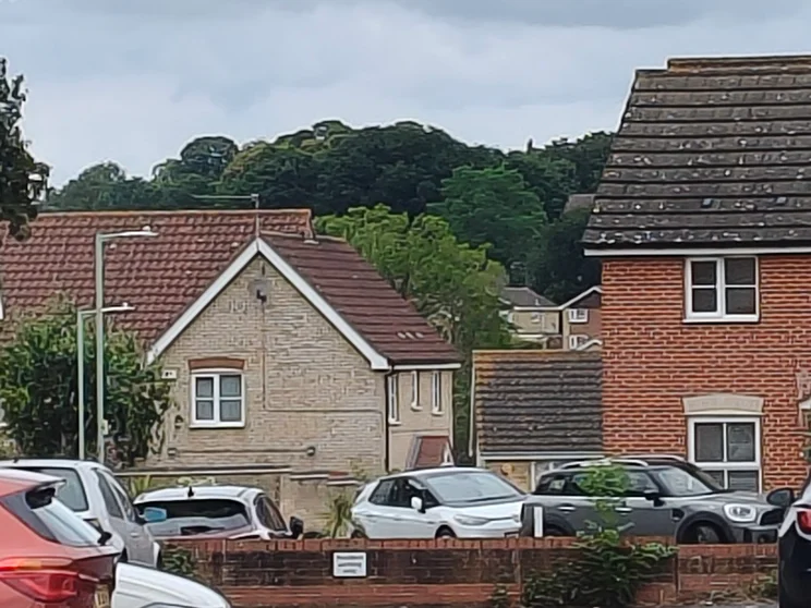 10x zoom of houses with trees in the background