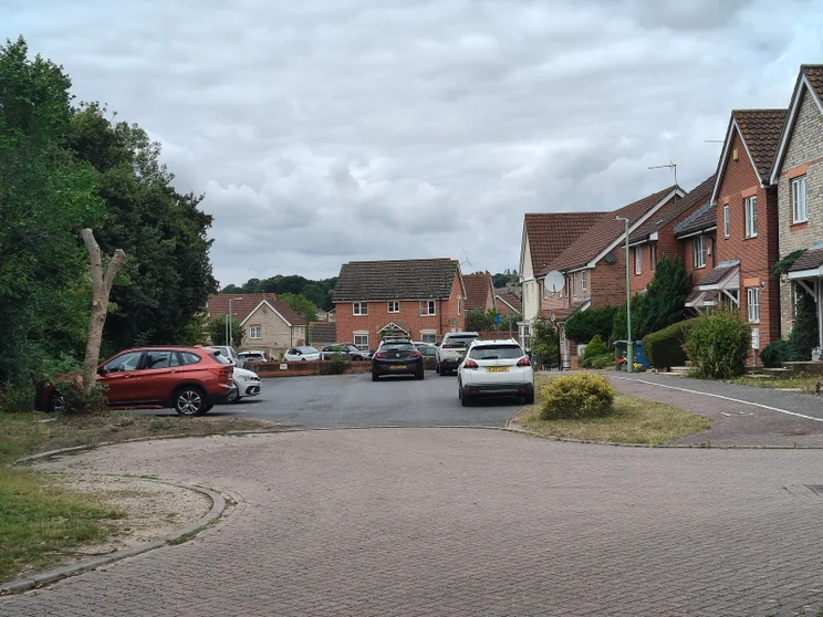 2x zoom of a close of houses with cars parked out front