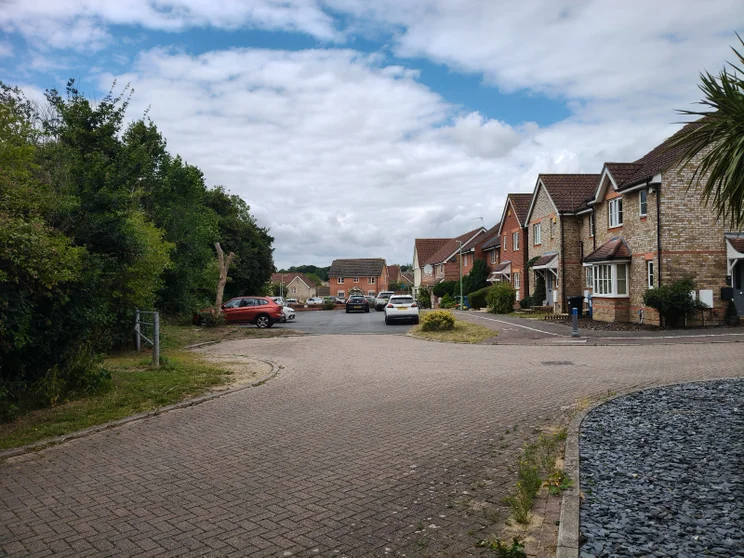 A quiet close of houses with cars parked out front