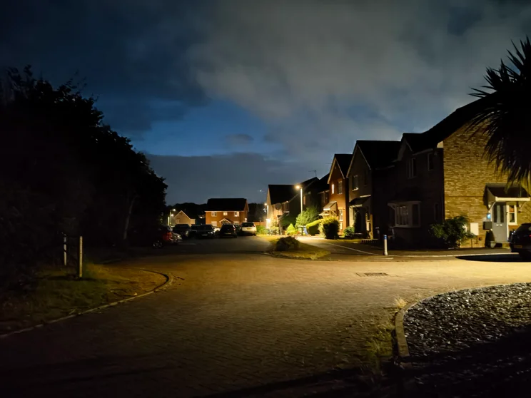 A quiet close at night with cars parked in front of the houses