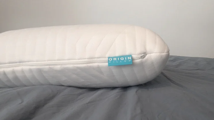 A side view of the Origin Coolmax Latex pillow, on a mattress