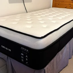 The Origin LumbarCloud mattress on a bedframe in a bedroom