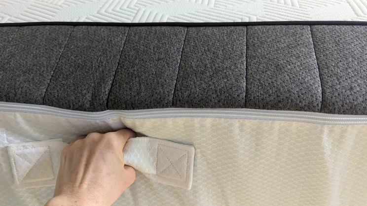 Holding the Panda Hybrid Bamboo mattress by its underside carry handles