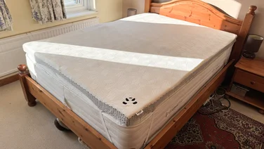 The Panda Hybrid Bamboo Mattress topper on a bed in a well-lit bedroom