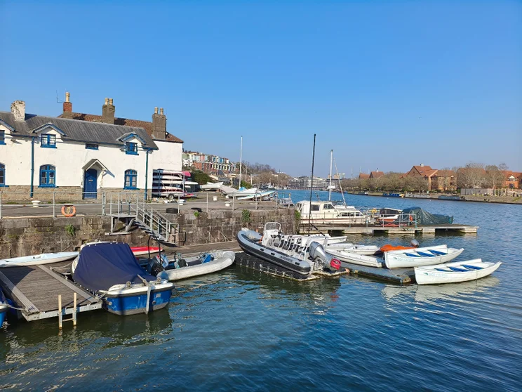 Boats moored at a jetty on a river