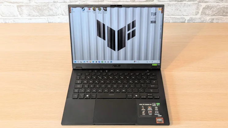 The Asus TUF Gaming A14 RTX 5060 laptop pictured from the front on a wood desk