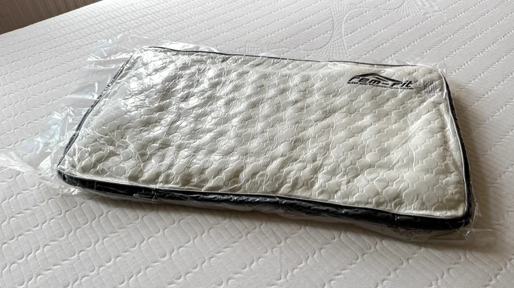 The REM-Fit Deluxe Pocket pillow, vacuum sealed, on a mattress