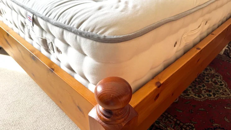 The corner of the REM-Fit Natural Lux Hybrid mattress, on a bed frame