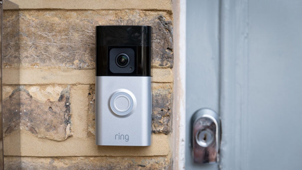 Ring Battery Doorbell Pro mounted on brick wall next to a grey door