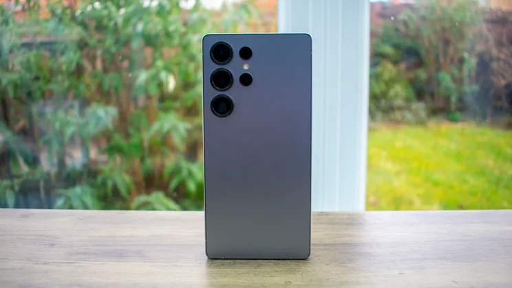 Samsung Galaxy S25 Ultra standing on a desk, rear view, in front of a window