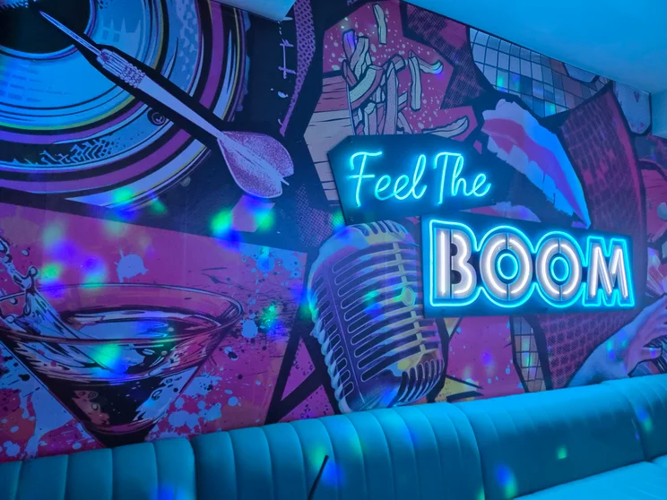 A graffitied wall with neon letters