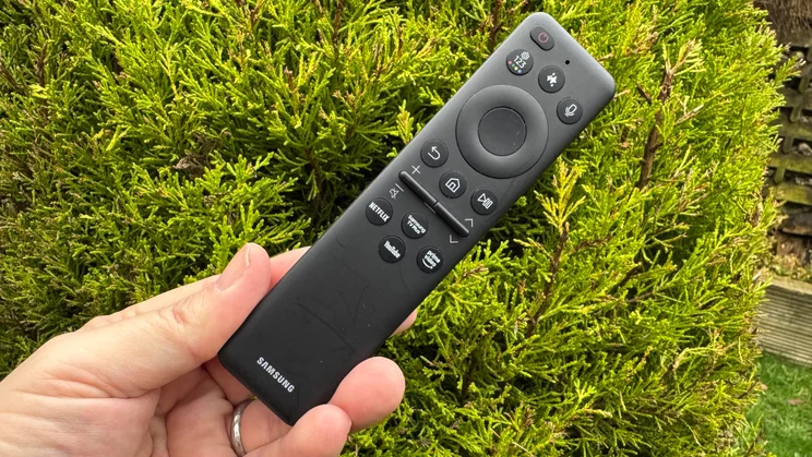 The pared-back remote control included with the Samsung R95H Micro LED TV being held in a hand