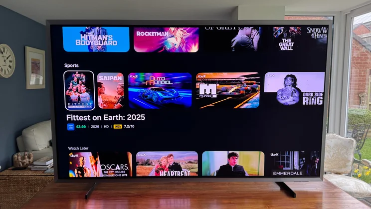 Front view of the Samsung S99H quantum dot OLED TV displaying the Tizen OS homepage