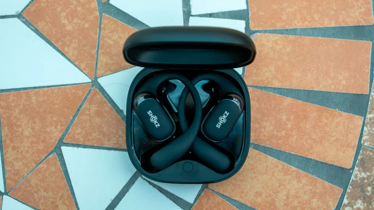 Shokz OpenFit 2 Plus in the charging case, top view, on a mosaic table