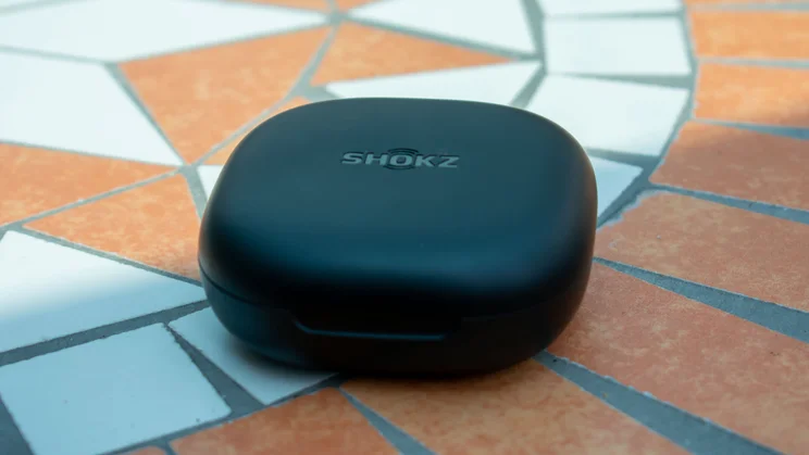 Shokz OpenFit 2 Plus case, closed, on a mosaic table