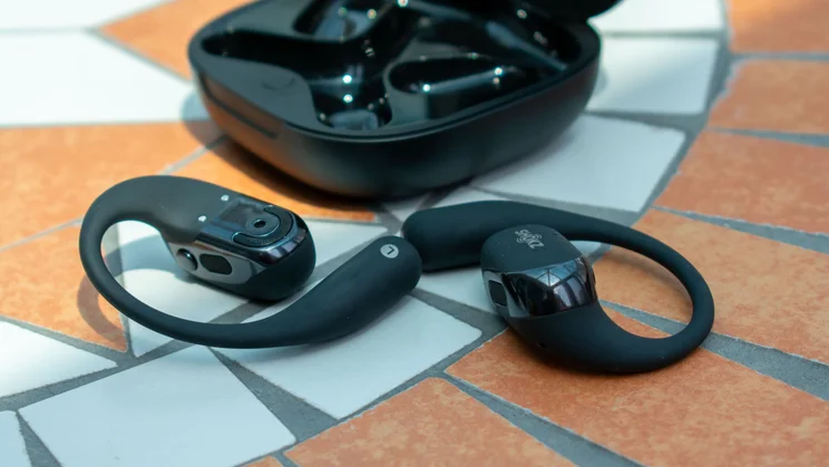 OpenFit 2 Plus in front of their charging case on a mosaic table