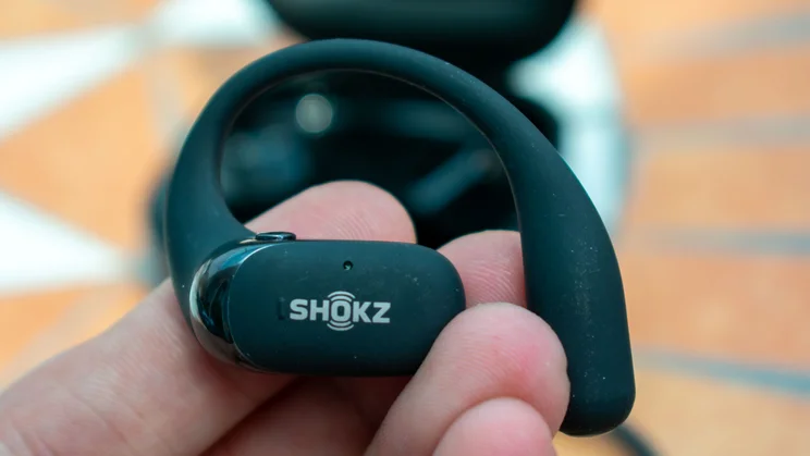 Shokz OpenFit 2 Plus earbud, in hand, front view