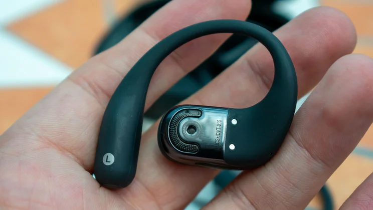 Shokz OpenFit 2 Plus earbud, in hand, rear view