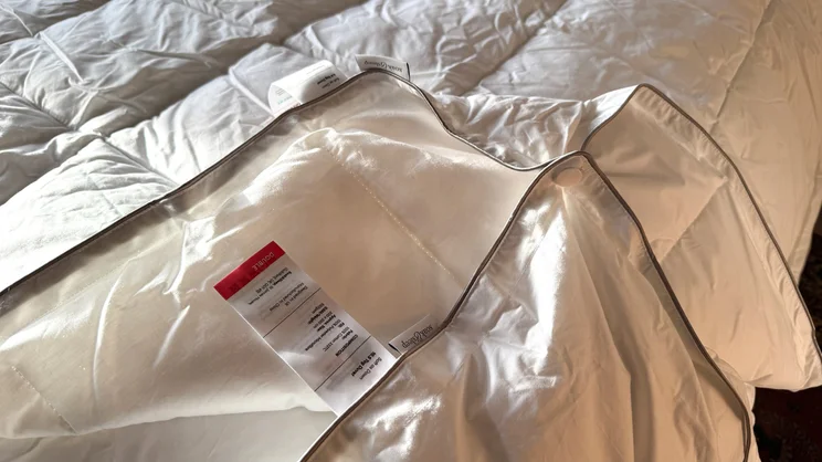 A closeup of the Soak & Sleep Soft as Down duvet's corner, showing its care label and fastener