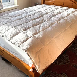 The Soak & Sleep Soft as Down duvet on a bed