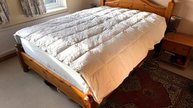 The Soak & Sleep Soft as Down duvet on a bed