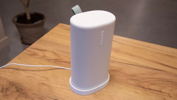 The white Sonos Play speaker in its charging base on a wooden table