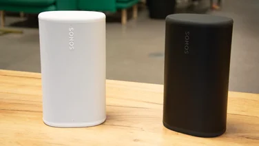 The white and black Sonos Play speakers next to each other on a wooden desk