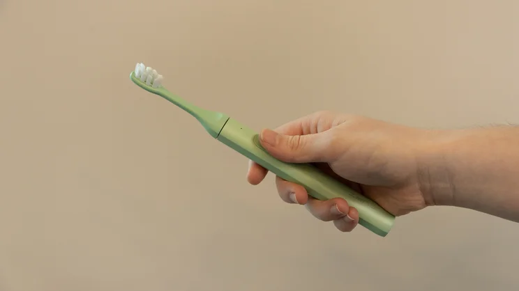 The Suri 2.0 electric toothbrush held in a hand