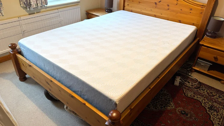 The TEMPUR EASE mattress on a wooden bed frame in a bedroom