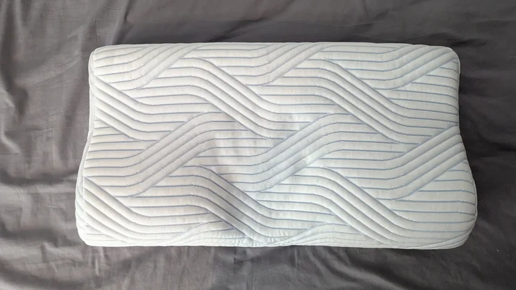 The Tempur Original SmartCool Pillow on a bed, viewed from above with a hand print in the middle